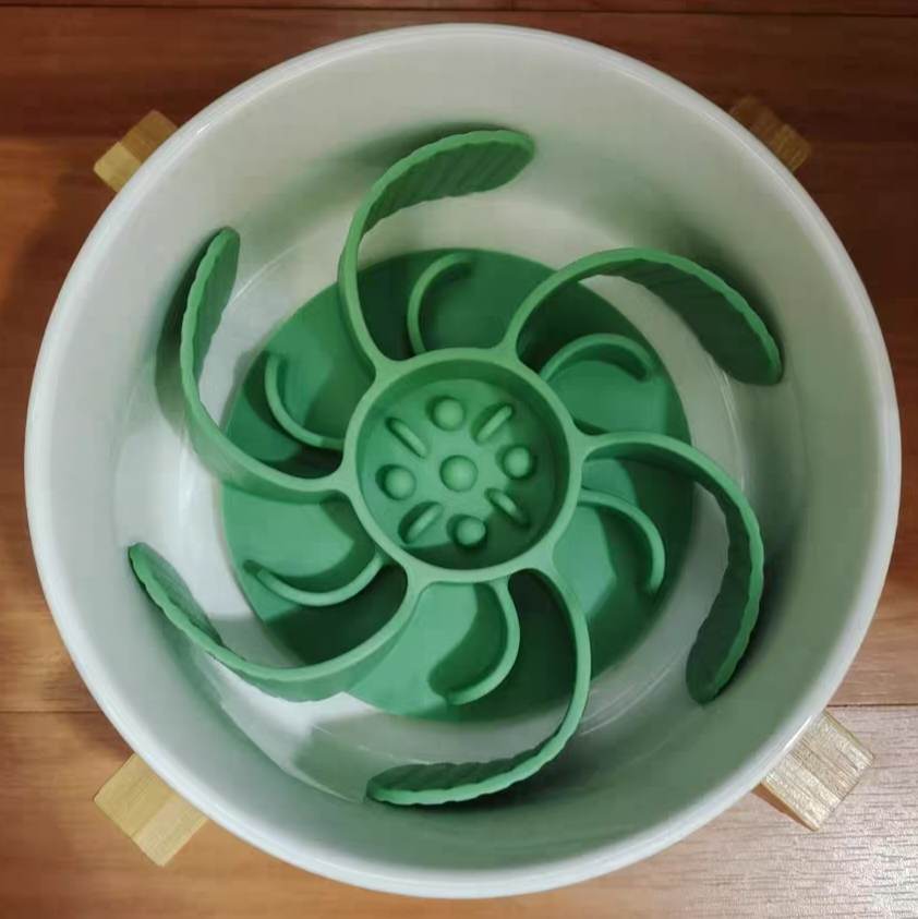A green slow feeder bowl insert designed to slow down the eating pace of pets, placed inside a white bowl.